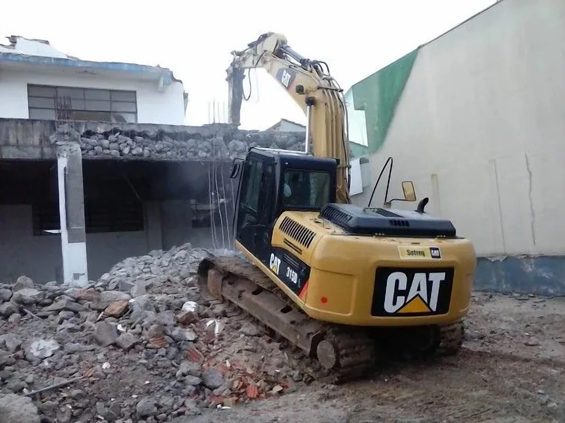 Escavadeira da Nobre Demolidora demolindo uma casa