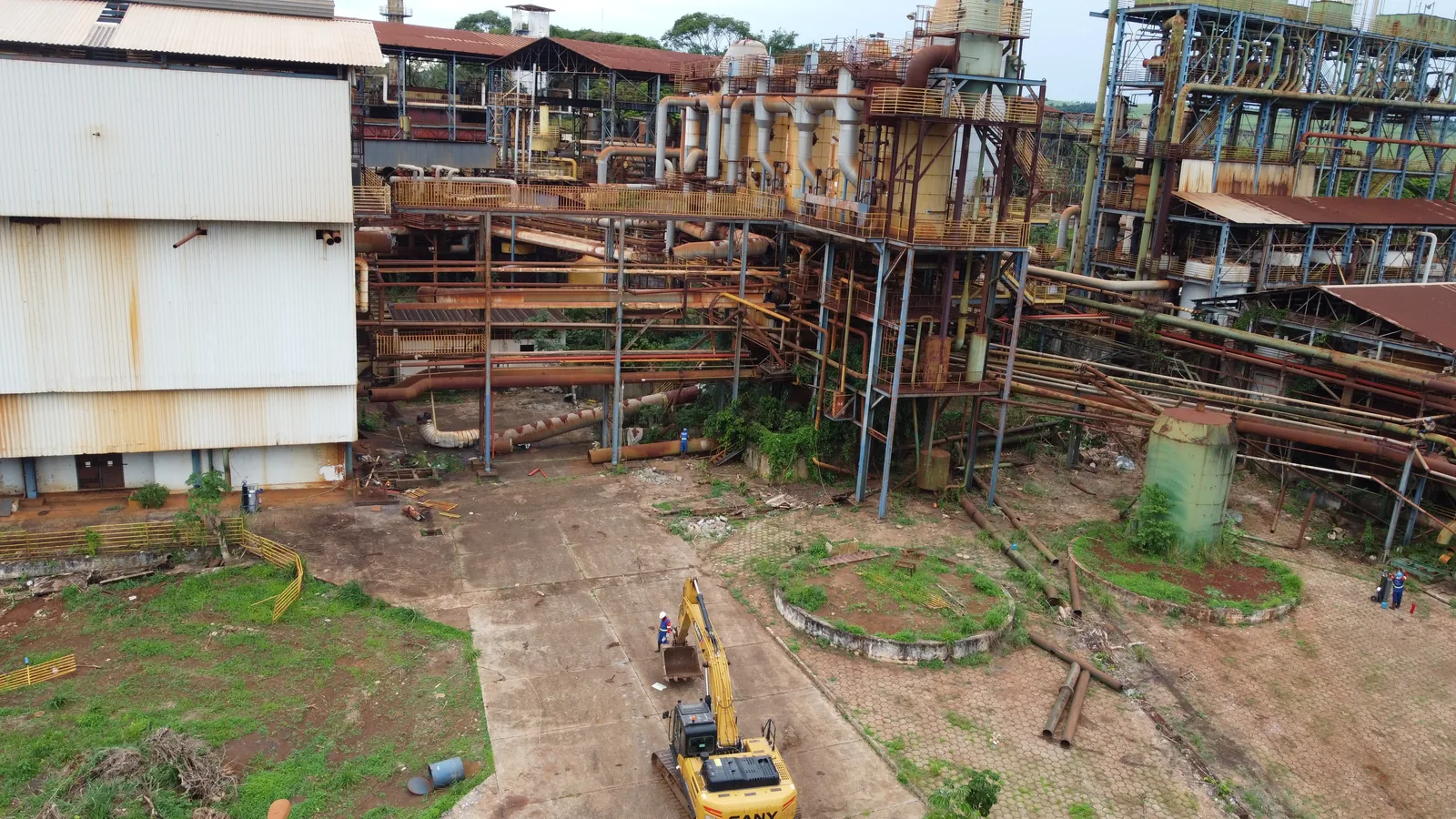 Escavadeira em demolição de estrutura metálica de fábrica